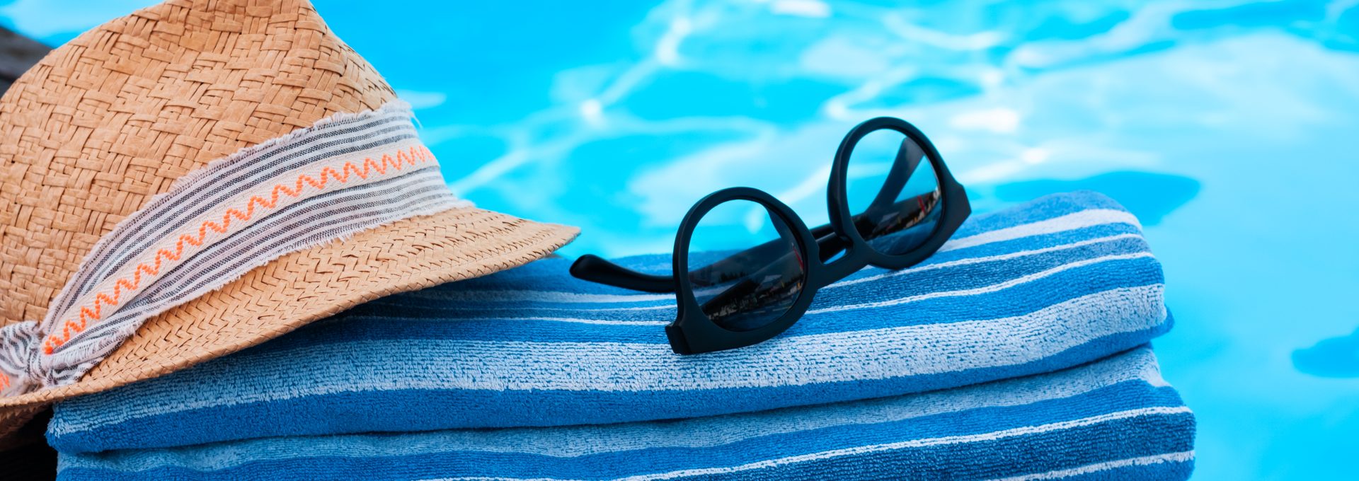 a hat, sunglasses and towel are placed on a pool deck at The Soltera Rolling Pines