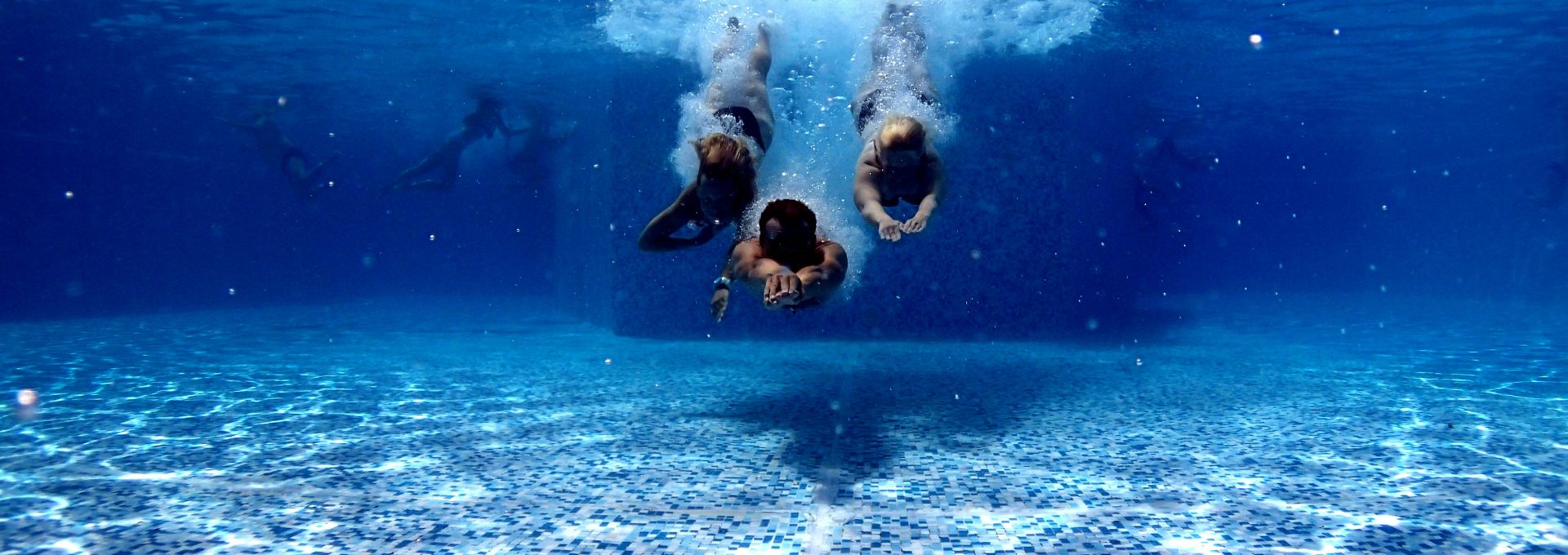 three person diving on water